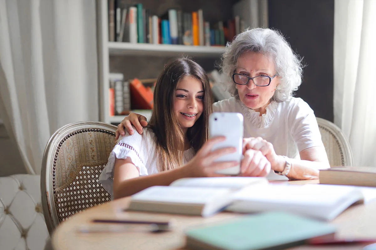 A grandmother and granddaughter looking at a smartphone together