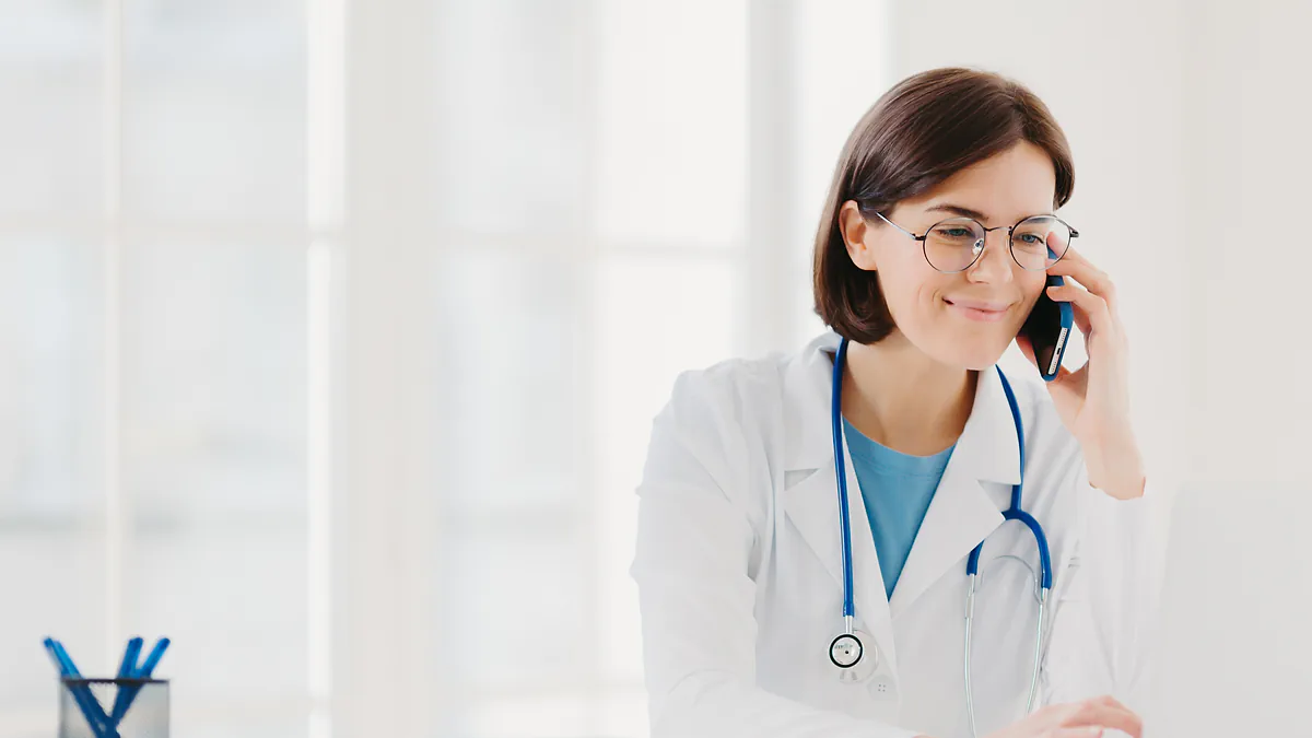 A smiling ophthalmologist on the phone at her desk