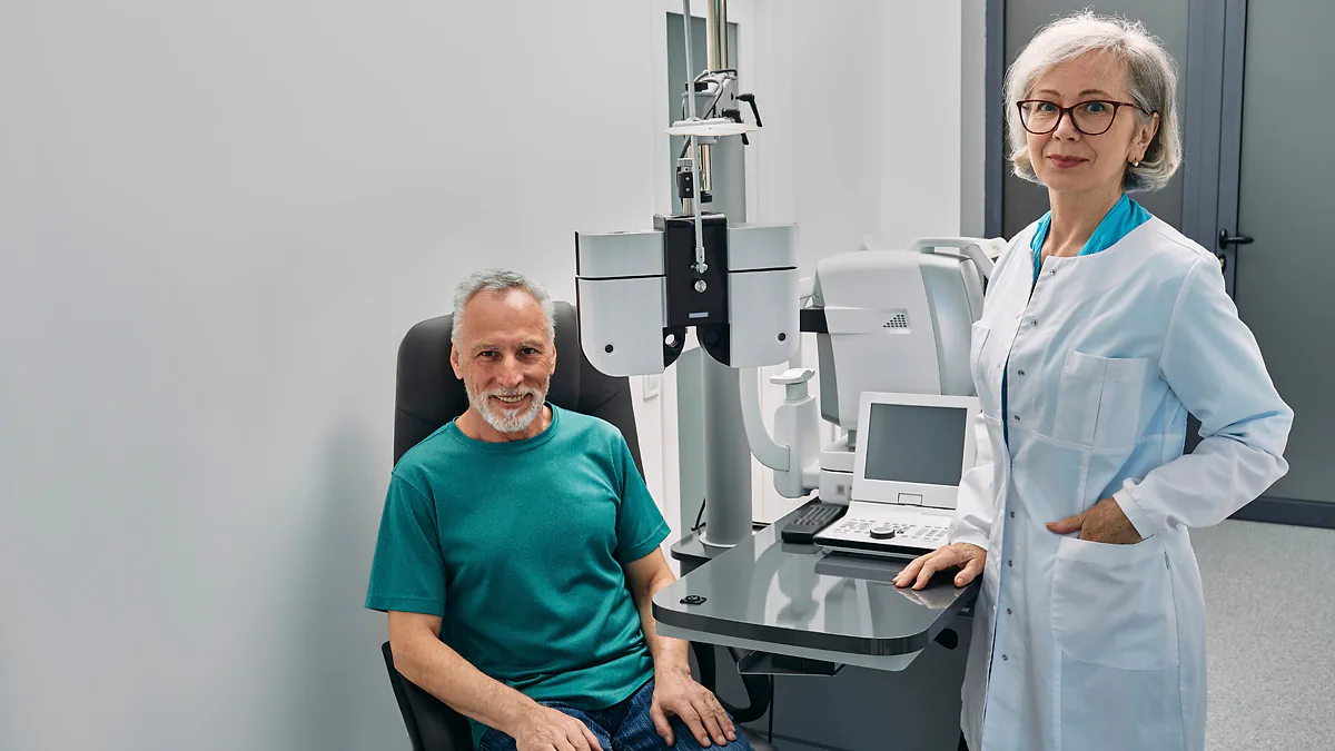 An optometrist beside a smiling patient in her examination room