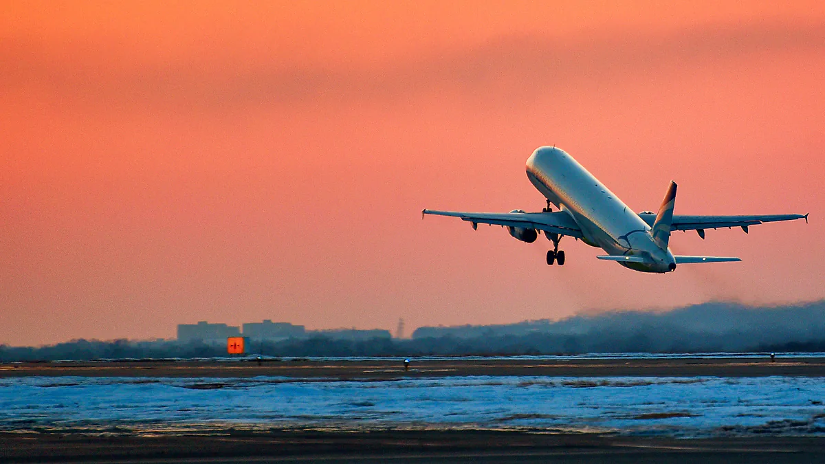 A plane taking off at sunset