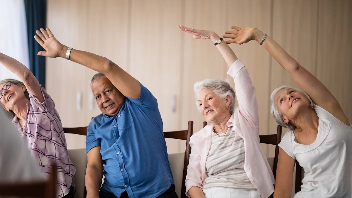 Older adults doing a seated side stretch together