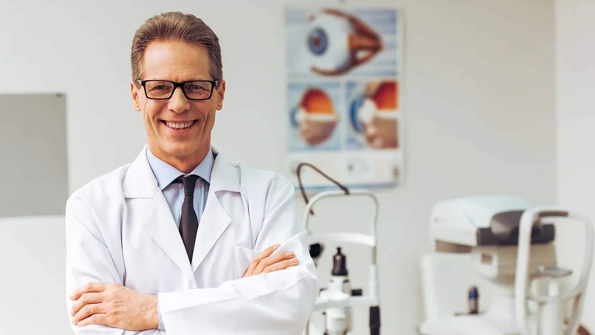 A smiling optometrist in his consulting room